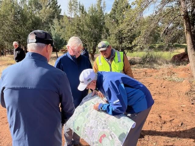 group of men looking at map while planning for golf construction